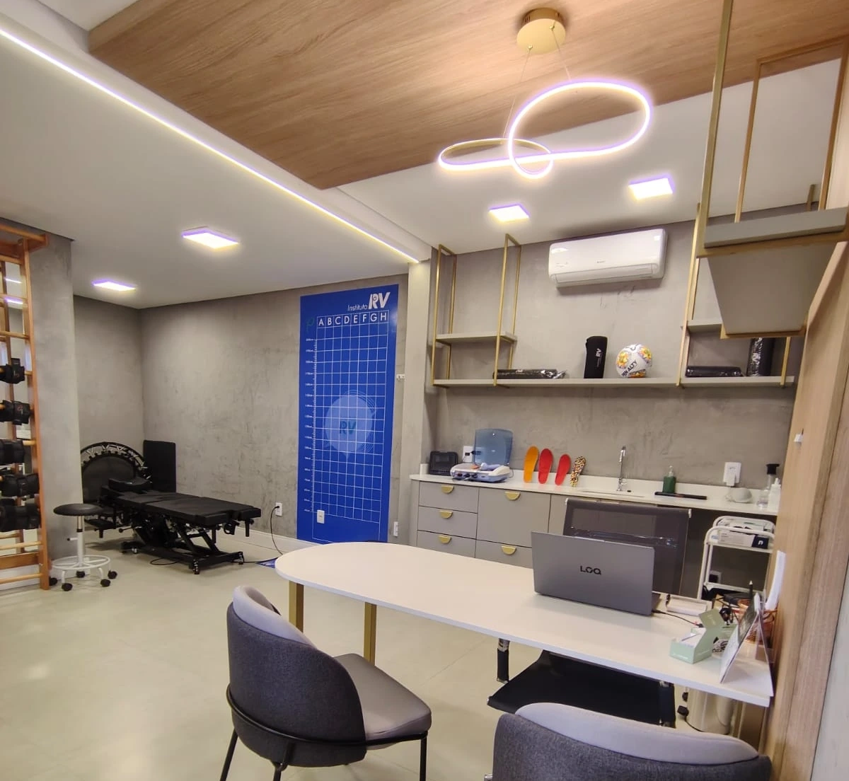 Consultório do Instituto RV com maca, mesa de atendimento e equipamentos de fisioterapia